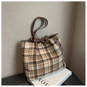 Détail du sac cabas en tweed à carreaux avec bandoulière en cuir brun et chaîne dorée