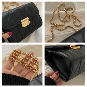 Detail view showing black quilted leather texture and gold metal chain strap of the bag