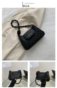 Detail of black faux leather shoulder bag featuring checkered texture and woven strap