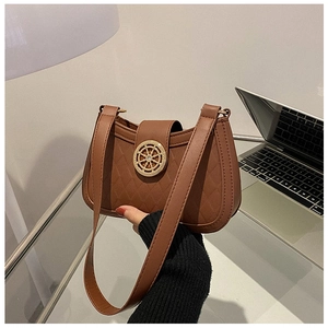 Détail du sac à bandoulière matelassé marron avec boucle vintage dorée en forme de roue
