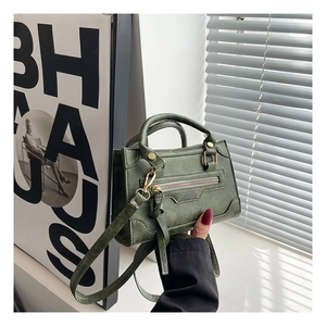 Dettaglio borsa a mano retrò verde scuro con nappe in pelle e finiture in bronzo