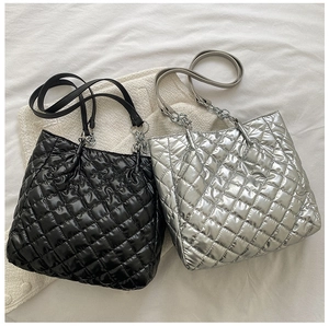 Detailansicht der gesteppten Tragetaschen in Schwarz und Silber mit Kettenriemen-Details