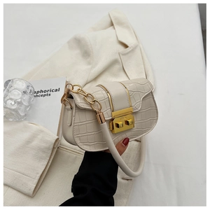 Close-up of beige crocodile texture leather bag with gold metal lock and chain strap