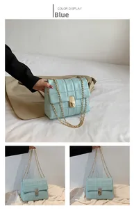 Detail of mint blue quilted crossbody bag with gold chain strap and metal lock closure