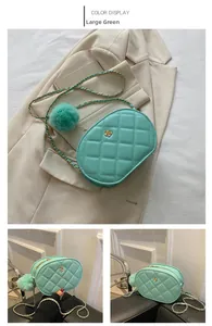 Detail view of mint green oval crossbody bag with quilted pattern and gold flower buckle