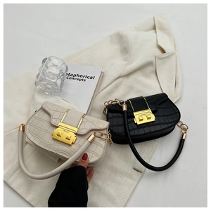Close-up of stone patterned shoulder bags with elegant gold metal locks and chain straps