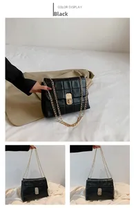 Detail of black quilted leather shoulder bag with gold chain strap and turn-lock closure