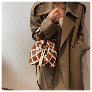 Detailed view of brown bucket bag with white geometric rhombus pattern and drawstring