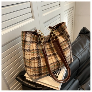 Détail du sac cabas en tweed à carreaux avec chaînes dorées et finitions en cuir