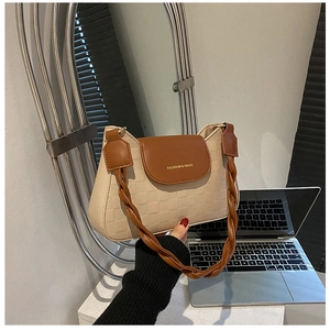 Detail of checkered embossed beige PU leather bag with woven shoulder strap
