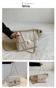 Detail view of a white quilted chain bag with a gold twist-lock and chain strap