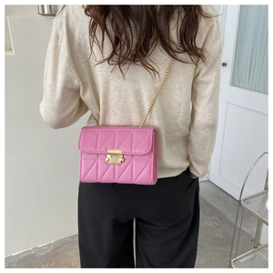 Pink quilted PU leather crossbody bag with gold chain strap shown on model shoulder