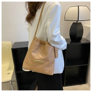 Detail of camel quilted bucket bag with chain strap and matching mini coin purse