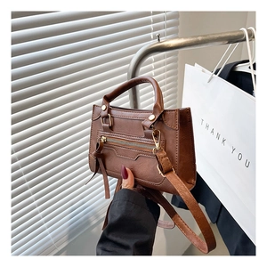 Dettaglio della borsa vintage in pelle PU marrone con trama litchi e decorazione con frange