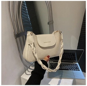 Detail of beige checkered embossed handbag with woven handle and gold fashion text logo