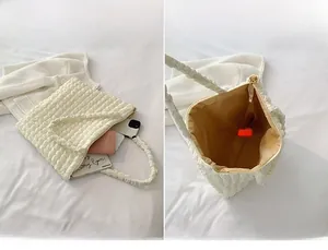 Dettaglio della borsa tote crema testurizzata con ampio scomparto principale e cerniera