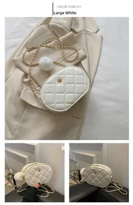 Detail view of quilted white oval bag with golden flower buckle and chain strap