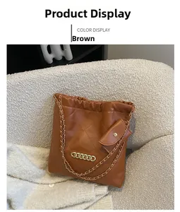Brown quilted chain shoulder bag with mini pouch on a cozy fleece armchair detail