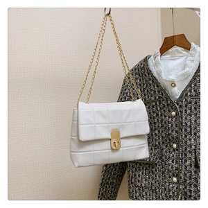 Close-up of white quilted chain bag with gold metal clasp and rectangular texture