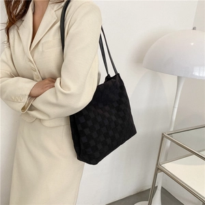 Sac fourre-tout noir à carreaux au design minimaliste porté par un mannequin urbain