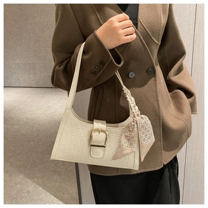 Detail of off-white faux crocodile texture shoulder bag with gold buckle and silk scarf