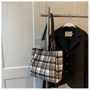 Détail du sac cabas à carreaux en tweed avec lanières en cuir et chaînes métalliques dorées