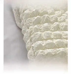 Vista dettagliata del tessuto a bolle bianco crema su una grande borsa tote donna