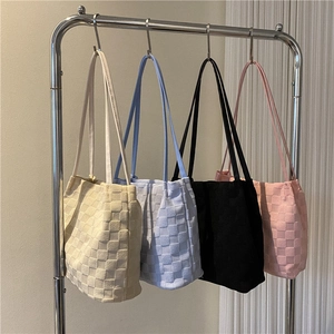 Sacs cabas minimalistes à damier en blanc cassé, bleu, noir et rose suspendus au mur