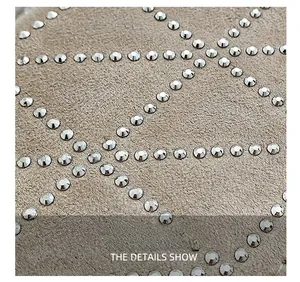 Detail of beige suede fabric featuring geometric patterns and silver rivet embellishments