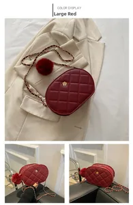 Detail view of large burgundy quilted shoulder bag with gold chain and floral accent