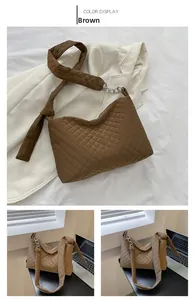 Detail of brown quilted tote bag with wide shoulder strap and silver chain accent