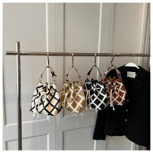 Detailed view of four quilted drawstring bucket bags in various contrast color combinations
