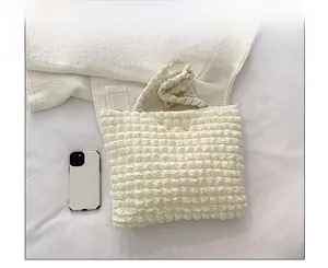 Dettaglio della borsa a bolle accanto a uno smartphone per il confronto delle taglie