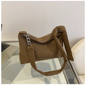 Detail of a brown quilted shoulder bag with diamond lattice pattern and silver chain strap