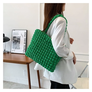 Dettaglio del tessuto texture popcorn verde vivace su una borsa a tracolla alla moda