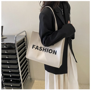 Chic beige PU leather tote bag with FASHION print styled with a black blazer