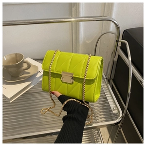 Close-up of neon green quilted faux leather bag with gold chain strap and metal lock