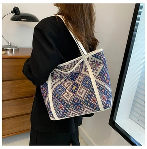 Detailed side view of ethnic woven tote bag with colorful geometric patterns on a shoulder