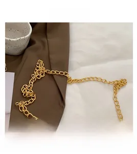 Dettaglio della borsa in peluche con motivo mucca e tracolla a catena d'oro spessa