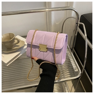 Detail of lavender quilted chain bag with gold metal lock and V-stitch texture