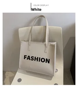 Detail view of a white minimalist tote bag with bold black FASHION print on matte leather