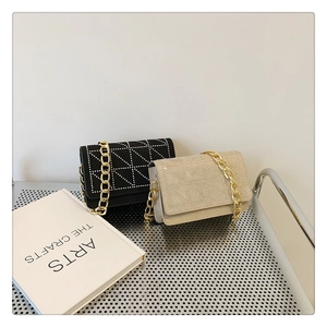 Detailed view of velvet flap bags in black and beige with bold gold chain straps