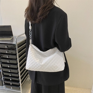 Classic white quilted tote bag with silver chain strap shown on model's shoulder