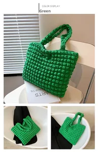 Dettaglio della borsa tote verde con trama a bolle 3D che mostra il tessuto plissettato