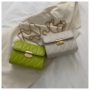 Close-up of quilted pattern leather bags with golden chain straps and metal buckles