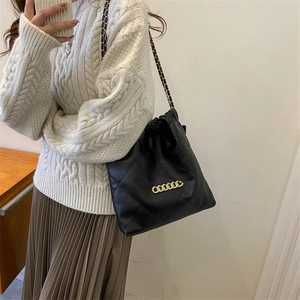 Chic black quilted drawstring bucket bag with gold chain and woven shoulder strap