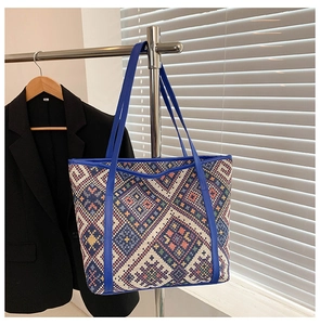 Macro shot of ethnic woven pattern and blue leather handle on large tote bag