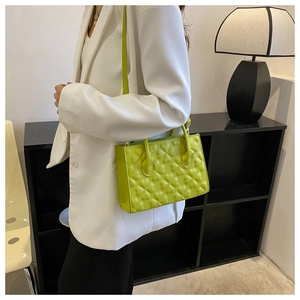 Detail showing the grass green PU leather handbag with 3D embossed clover texture