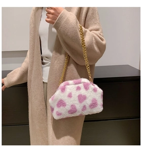 Dettaglio della borsa a tracolla in peluche bianca con cuori rosa e catena in metallo oro
