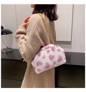 Dettaglio della borsa a tracolla in peluche con motivo a cuori e catena dorata